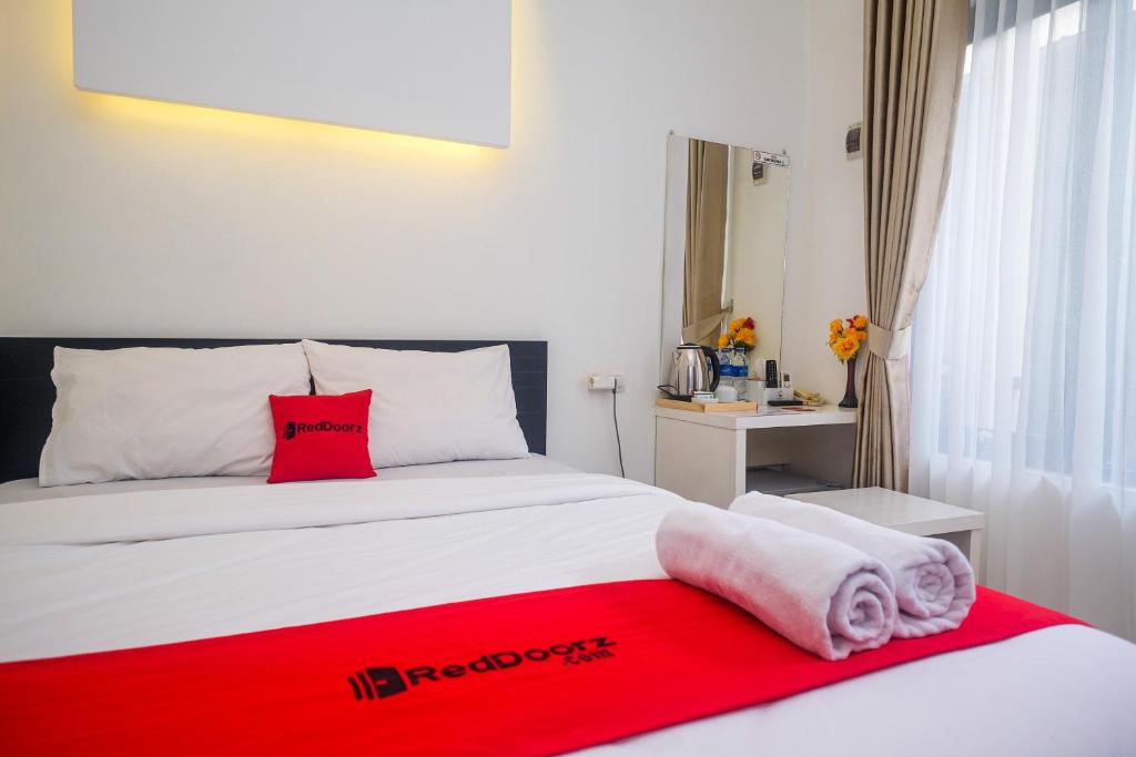 Un dormitorio con una cama con una manta roja. en RedDoorz near Ambarrukmo Area en Demangan