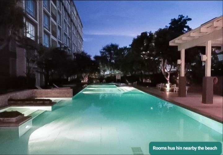 a large blue swimming pool in a building at Rooms hua hin nearby the beach in Hua Hin