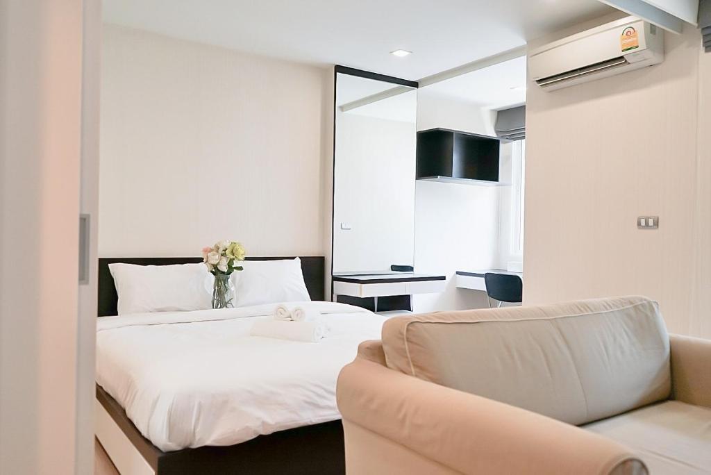 a hotel room with a bed and a couch at 5 mins to BTS Ekkamai, One Bed Fully-Furnished in Bangkok