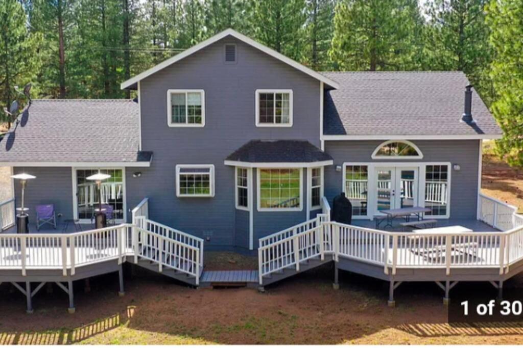 ein blaues Haus mit einer Veranda und einer Terrasse in der Unterkunft The Peaceful Escape: Hiking, Fishing, sleeps-12 in Susanville