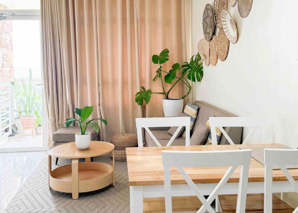 a living room with plants and a table and chairs at Nordic 1BR in Twin Lakes Tagaytay LL3-G in Tagaytay