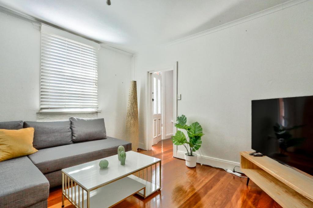 ein Wohnzimmer mit einem Sofa und einem Tisch in der Unterkunft Close to City 3 Bedroom House Surry Hills 2 E-Bikes Included in Sydney