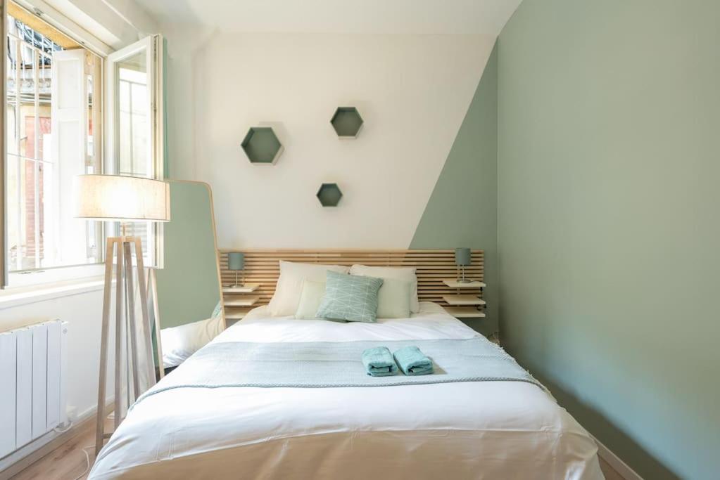 a bedroom with a bed with two blue shoes on it at Studio Centre-ville Sur Cour in Toulouse