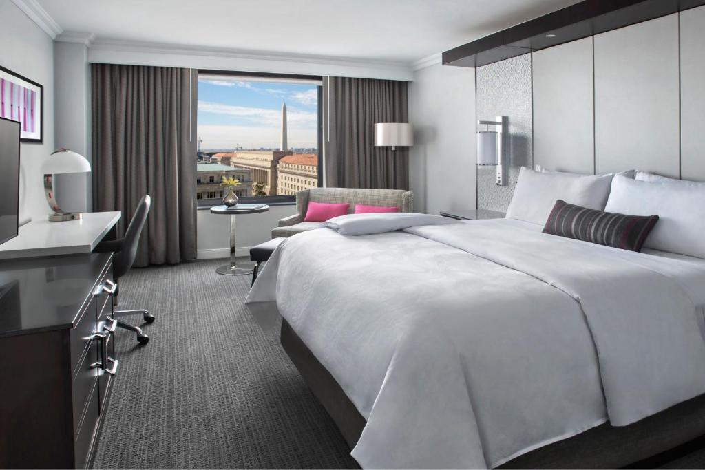 Habitación de hotel con cama blanca grande y balcón. en JW Marriott Washington, DC, en Washington