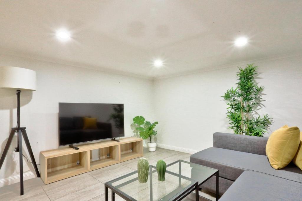 a living room with a couch and a tv at Good for Family 3 Bedroom House Darlinghurst with 2 E-Bikes Included in Sydney