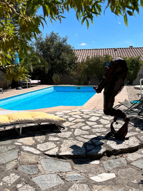 une statue d'une personne marchant à côté d'une piscine dans l'établissement La villa tranquille, à Roquebrune-sur Argens