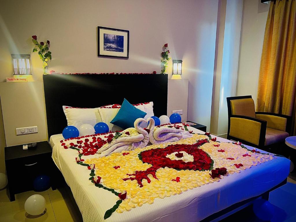 Un dormitorio con una cama grande con un diseño floral. en Hotel Excalibur en Kottayam