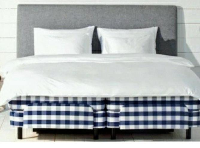 Cama con manta y almohadas azules y blancas en Relax huset, en Malmö