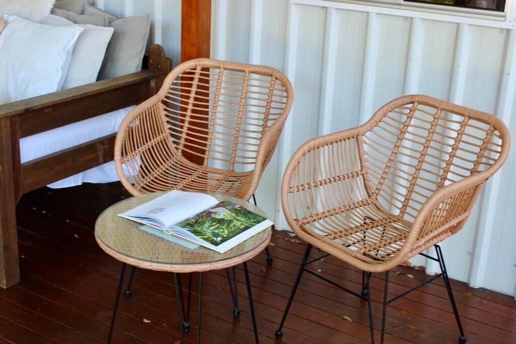 two wicker chairs with a book on a table at CC's @ Byron Self Contained Studio in Byron Bay
