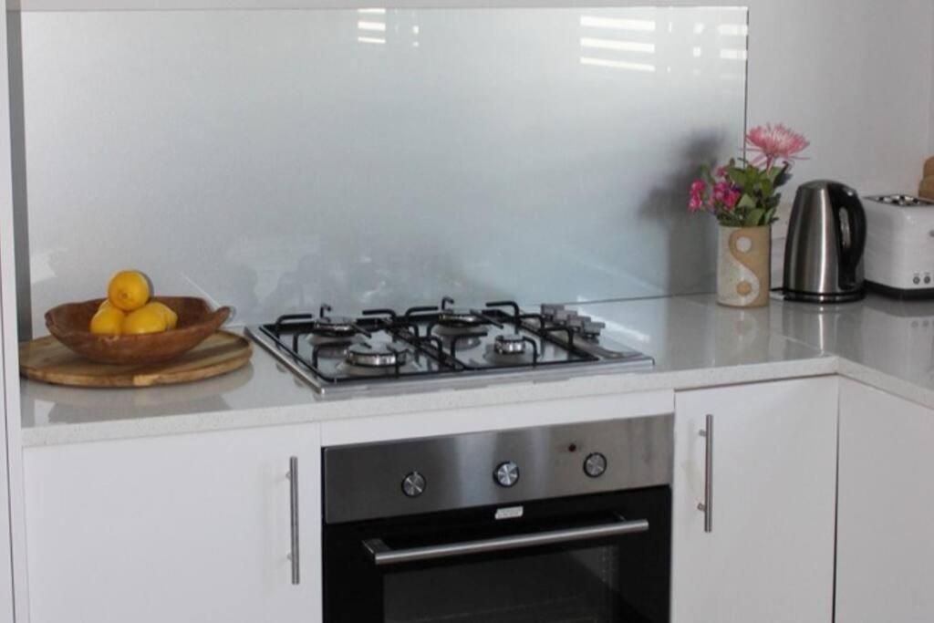 a kitchen with a stove and a bowl of fruit at CC's @ Byron Self Contained Studio in Byron Bay