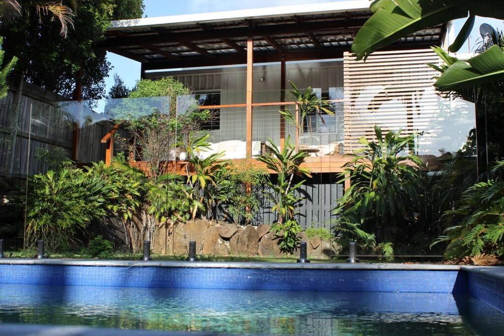 a house with a swimming pool in front of a building at CC's @ Byron Self Contained Studio in Byron Bay