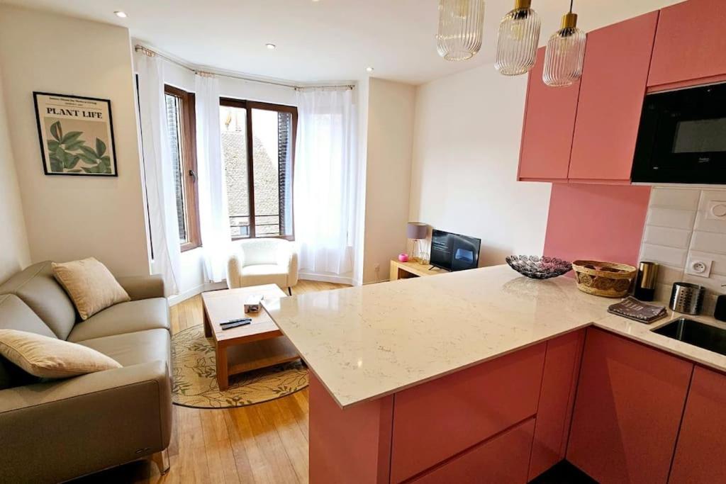 a kitchen with red cabinets and a living room at Lilas Rose in Thonon-les-Bains