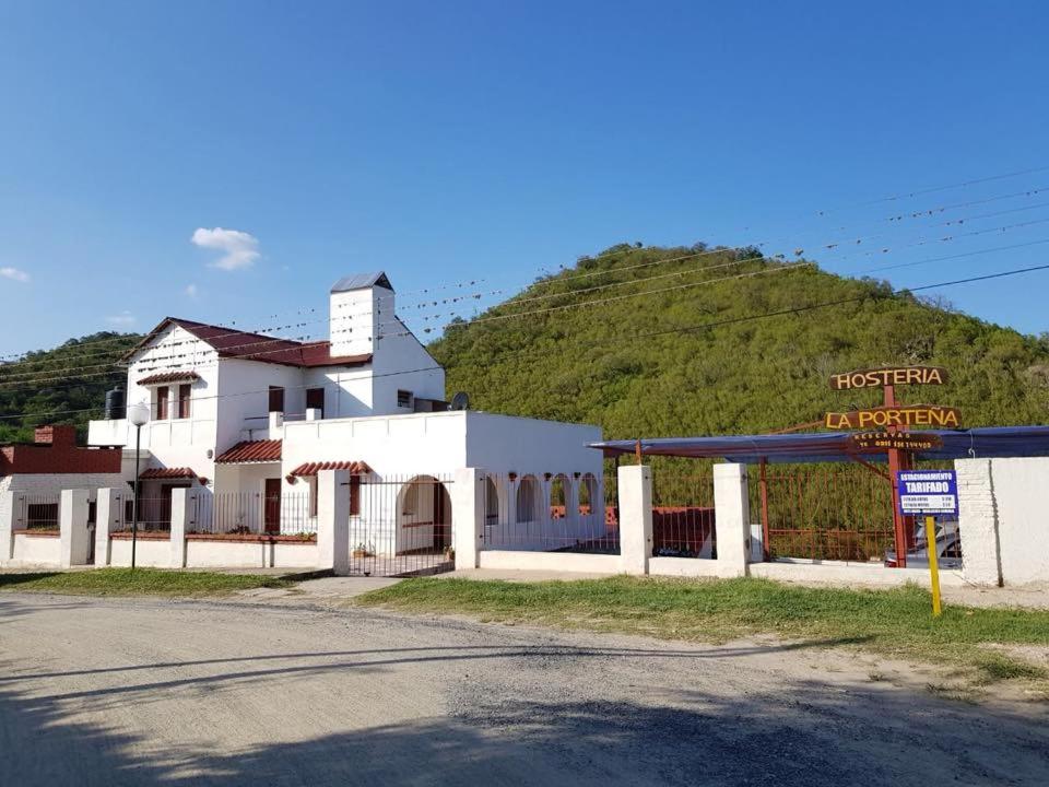 a white building with a mountain in the background at Hostería La Porteña - La Serranita in La Bolsa