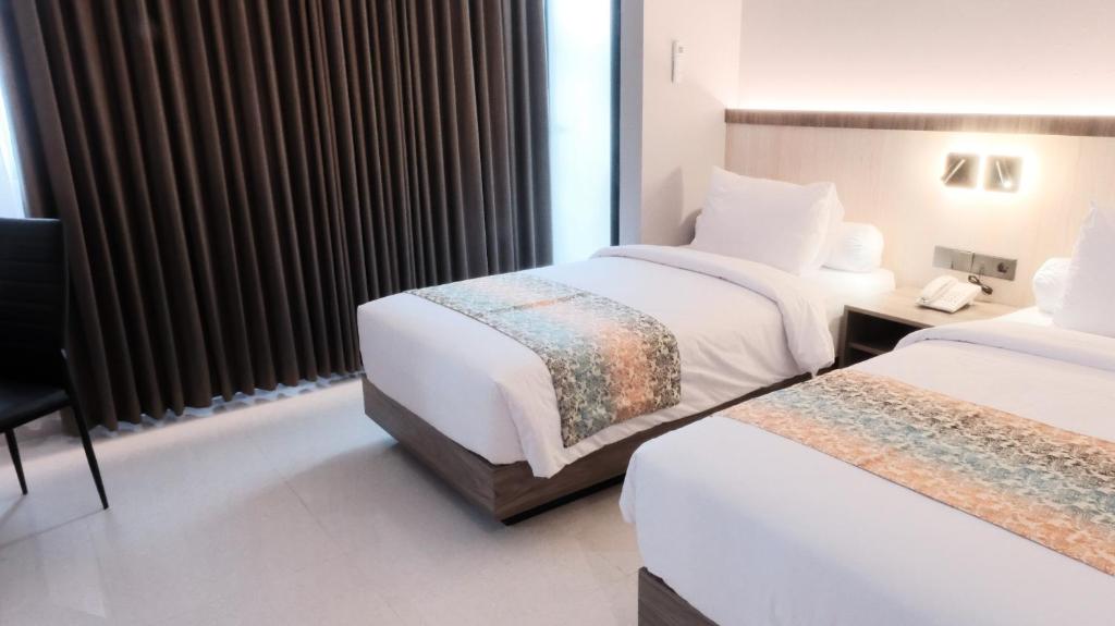 Postel nebo postele na pokoji v ubytování Eno Front One Hotel Semarang