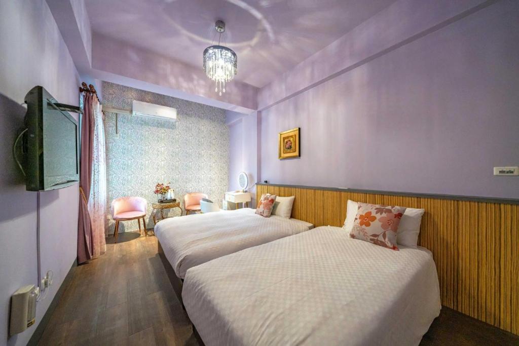 two beds in a room with purple walls at Sunny Homestay in Ji&#39;an
