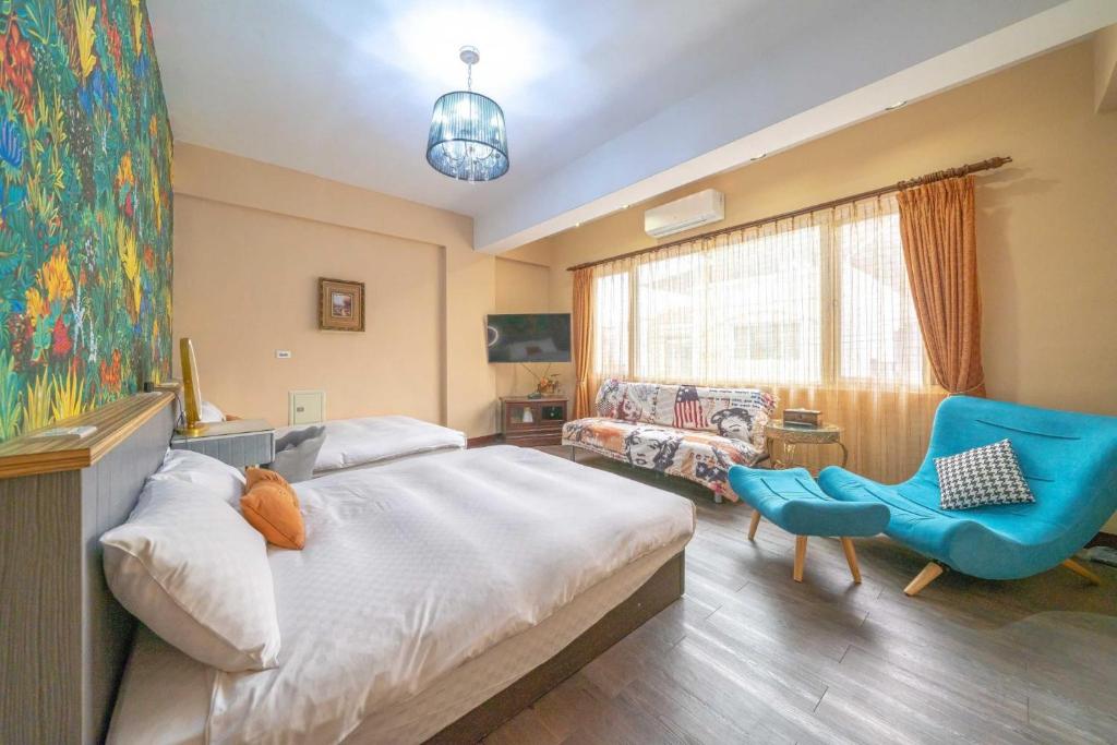 a bedroom with a bed and a blue chair at Sunny Homestay in Ji&#39;an