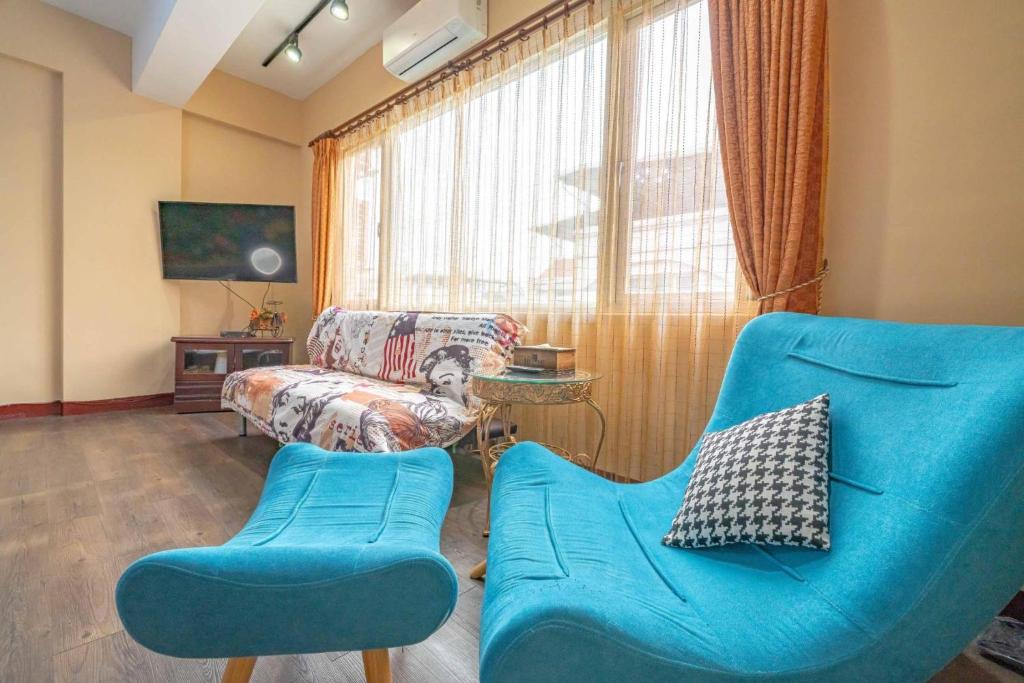 a living room with a blue couch and a chair at Sunny Homestay in Ji&#39;an