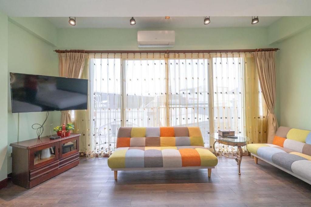a living room with a couch and a flat screen tv at Sunny Homestay in Ji&#39;an