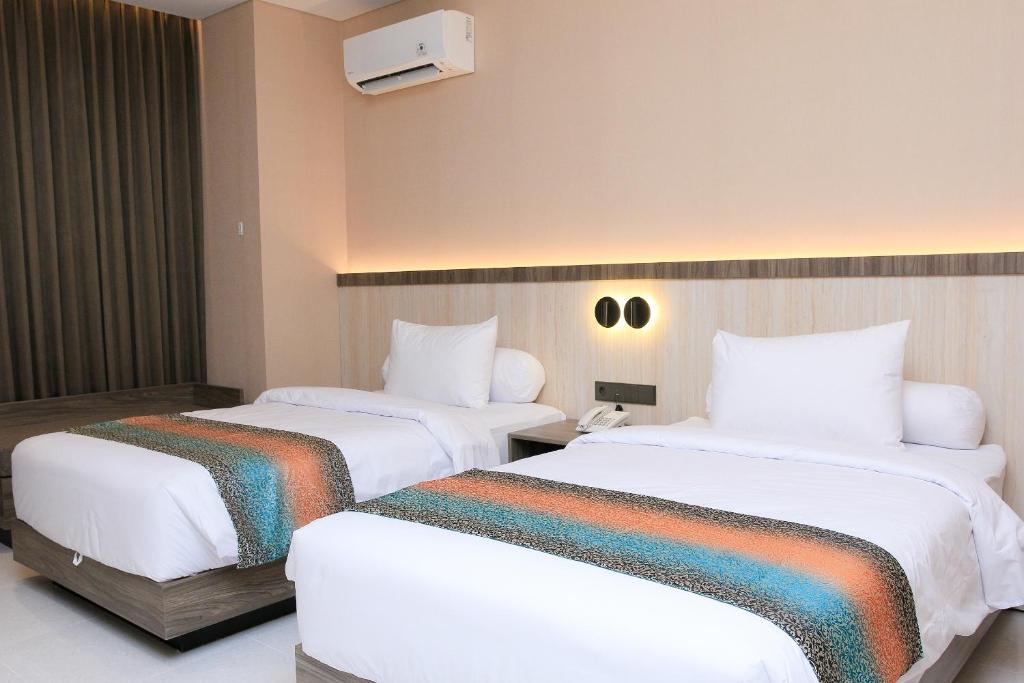 Postel nebo postele na pokoji v ubytování Eno Front One Hotel Semarang