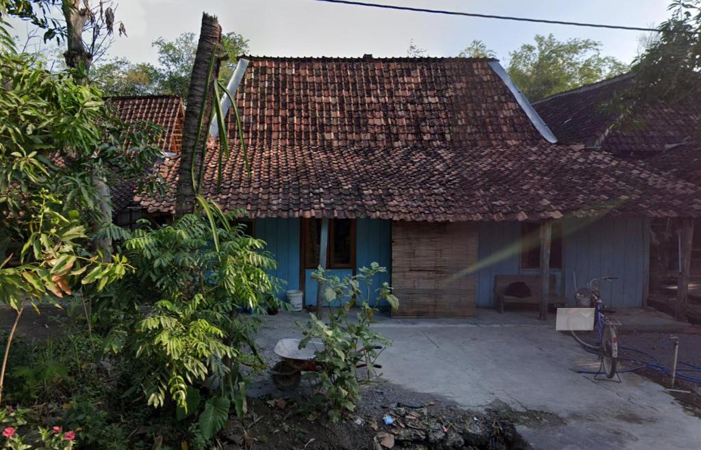 una casa con techo de baldosa y patio en Omah Ngiyup en Semarang