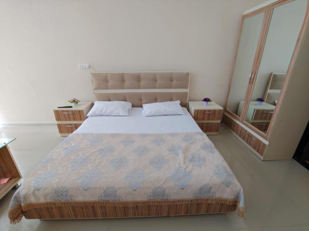 een slaapkamer met een groot bed en een grote spiegel bij Lahore Hotel Baku in Baku