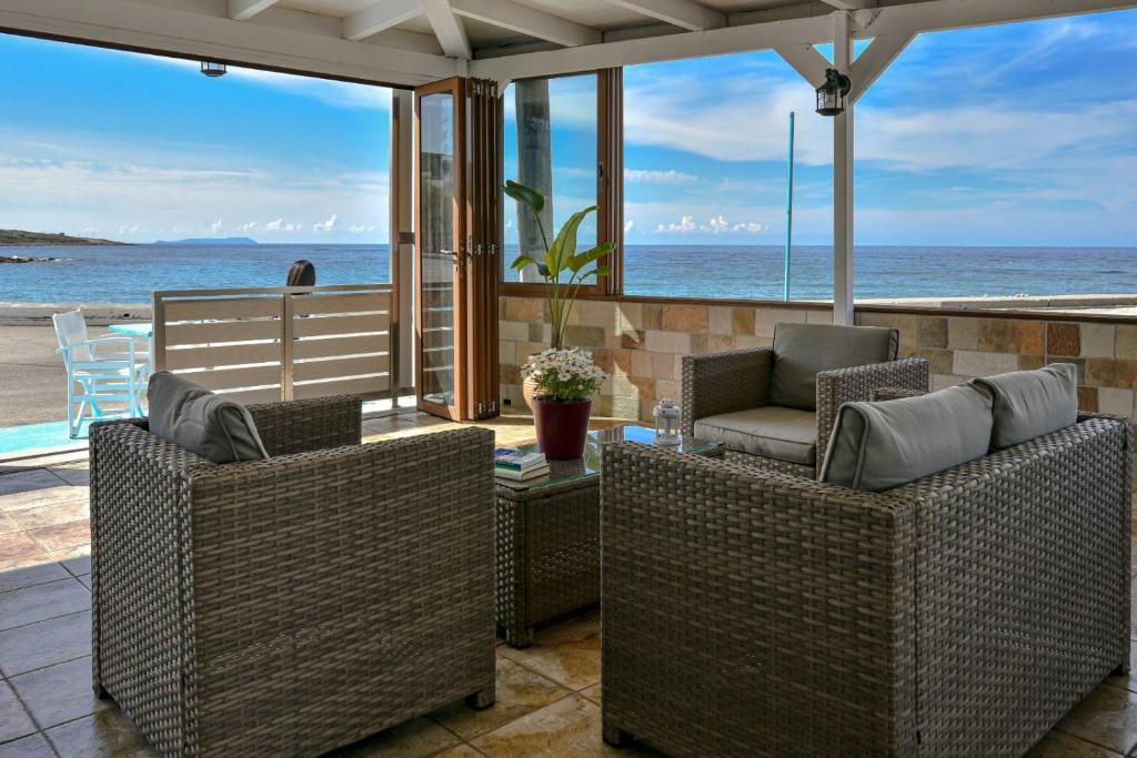 a patio with two chairs and a table and the ocean at Villa Thalassa in Milatos