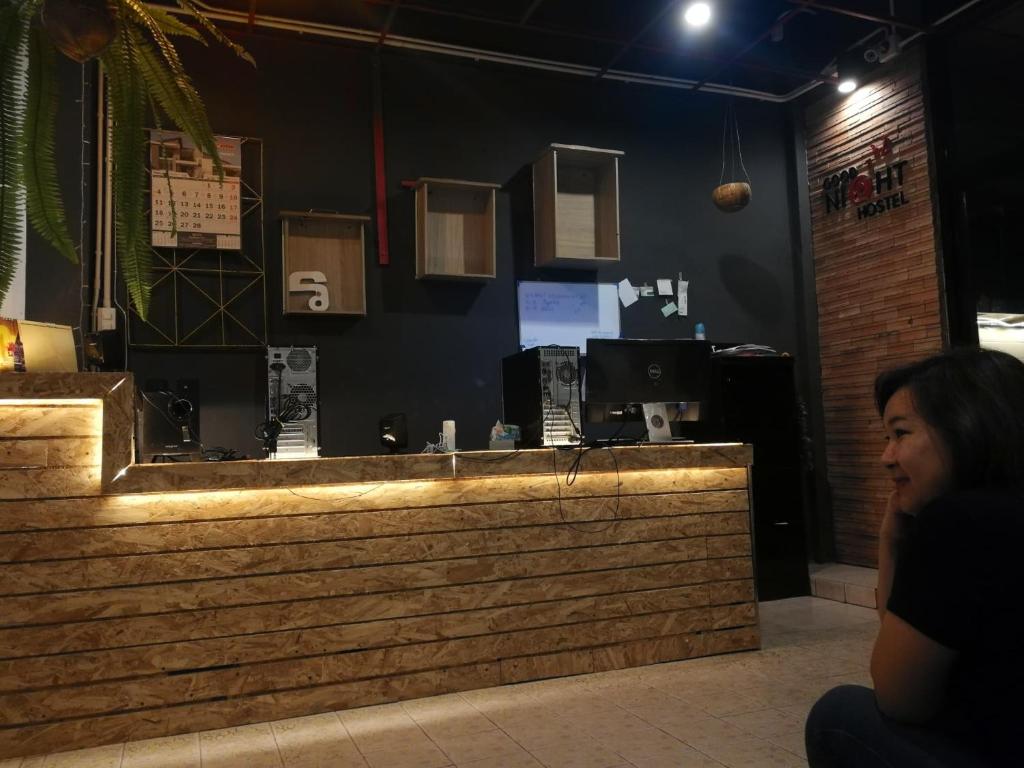 a woman sitting at a bar in a restaurant at Goodnighthostel@Trang in Trang