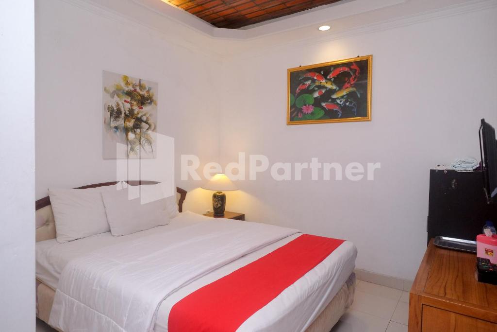 - une chambre avec un lit et une télévision dans l'établissement Ndalem Pundhi Maguwoharjo RedPartner, à Seturan