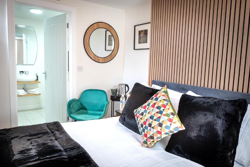 a bedroom with a bed with a mirror and a chair at Kings Arms Suites - Luxury Double - Freestanding Bath - Self Check In in Whitehaven
