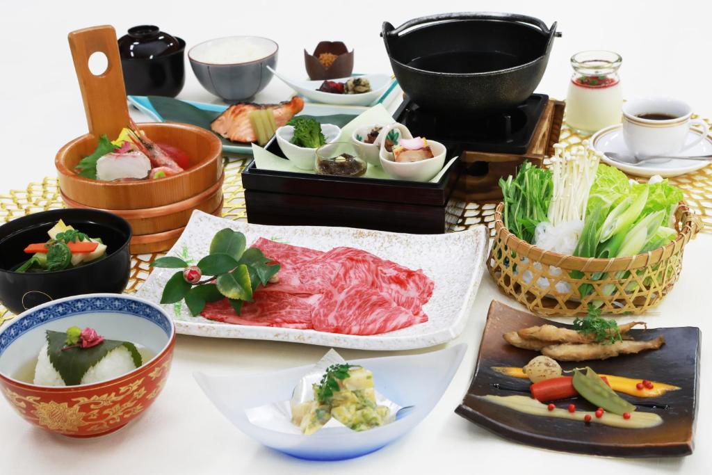 a table with various dishes of food on it at Hotel Binario Saga Arashiyama in Kyoto