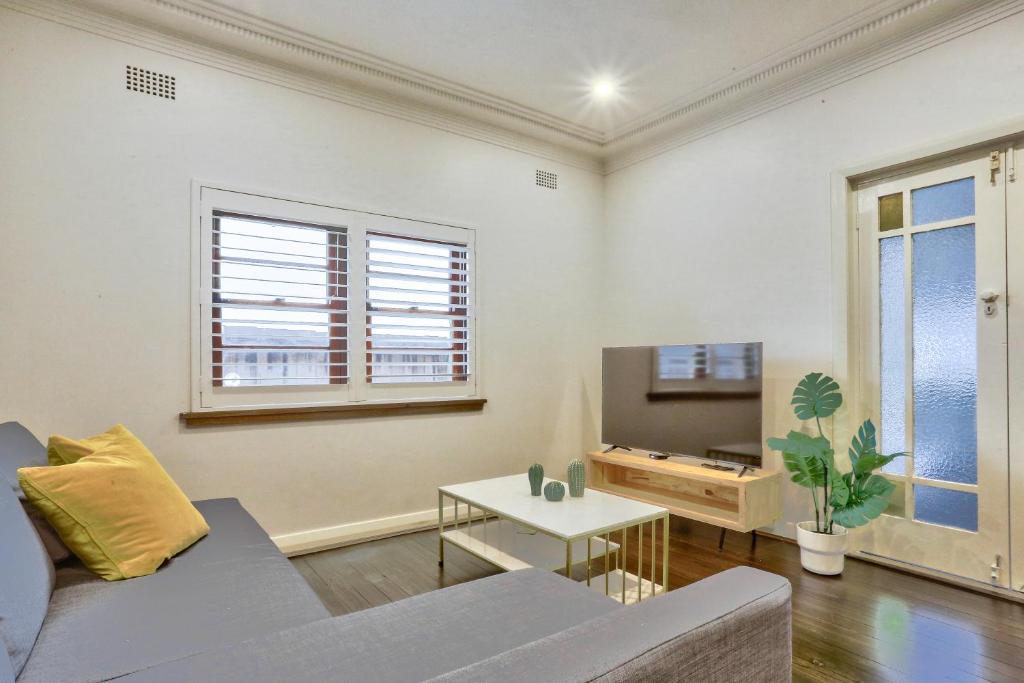 a living room with a couch and a tv at Spacious 3 Bedroom on the edge of Downtown Herford St 2 E-Bikes Included in Sydney