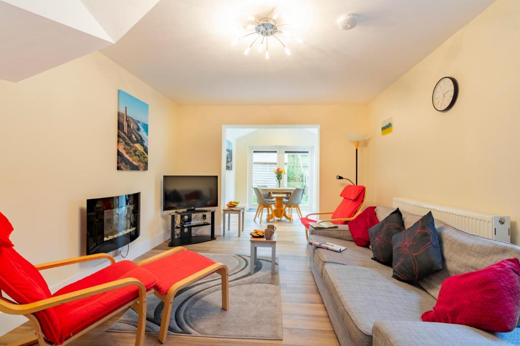 a living room with a couch and chairs and a tv at Cornish Holiday - Meadow Rise in Saint Columb Major