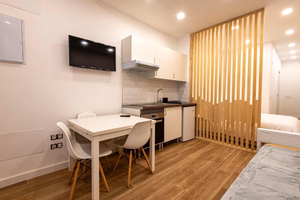 una pequeña cocina con mesa y sillas en una habitación en A Madrid centro, metro 2 min a pie, en Madrid