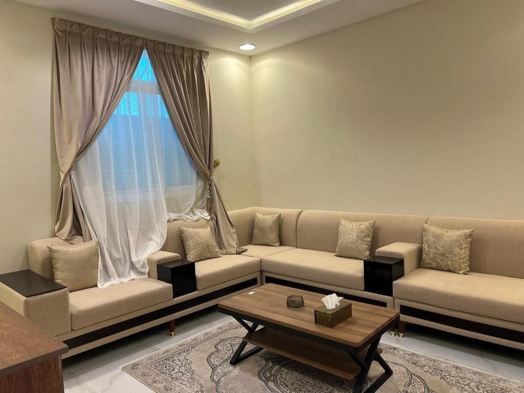 - un salon avec un canapé et une table basse dans l'établissement السلطان للشقق المفروشة, à Al-Ula