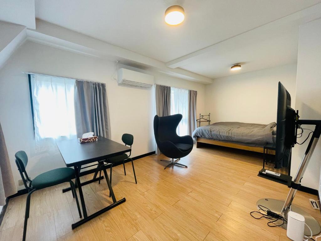 a room with a desk and a bed and a television at home shinjuku west301 in Tokyo