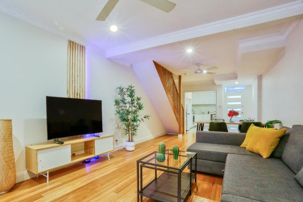 a living room with a couch and a flat screen tv at Vibrant 3 Bedroom House Darlinghurst 2 E-Bikes Included in Sydney