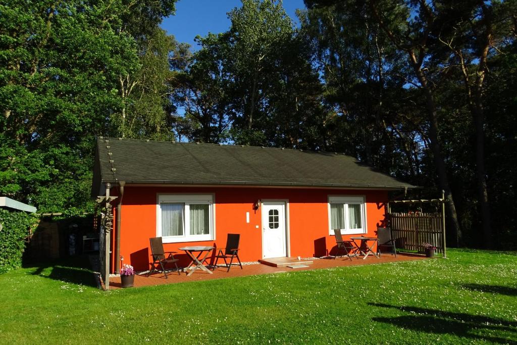 una piccola casa arancione con sedie e tavolo di Kölp - Gentz H a Kölpinsee auf Usedom