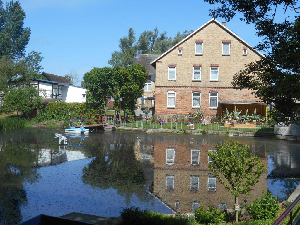 een groot bakstenen gebouw en een rivier met een huis bij Lake View Apartment in Klein Pravtshagen with Garden in Klein Pravtshagen
