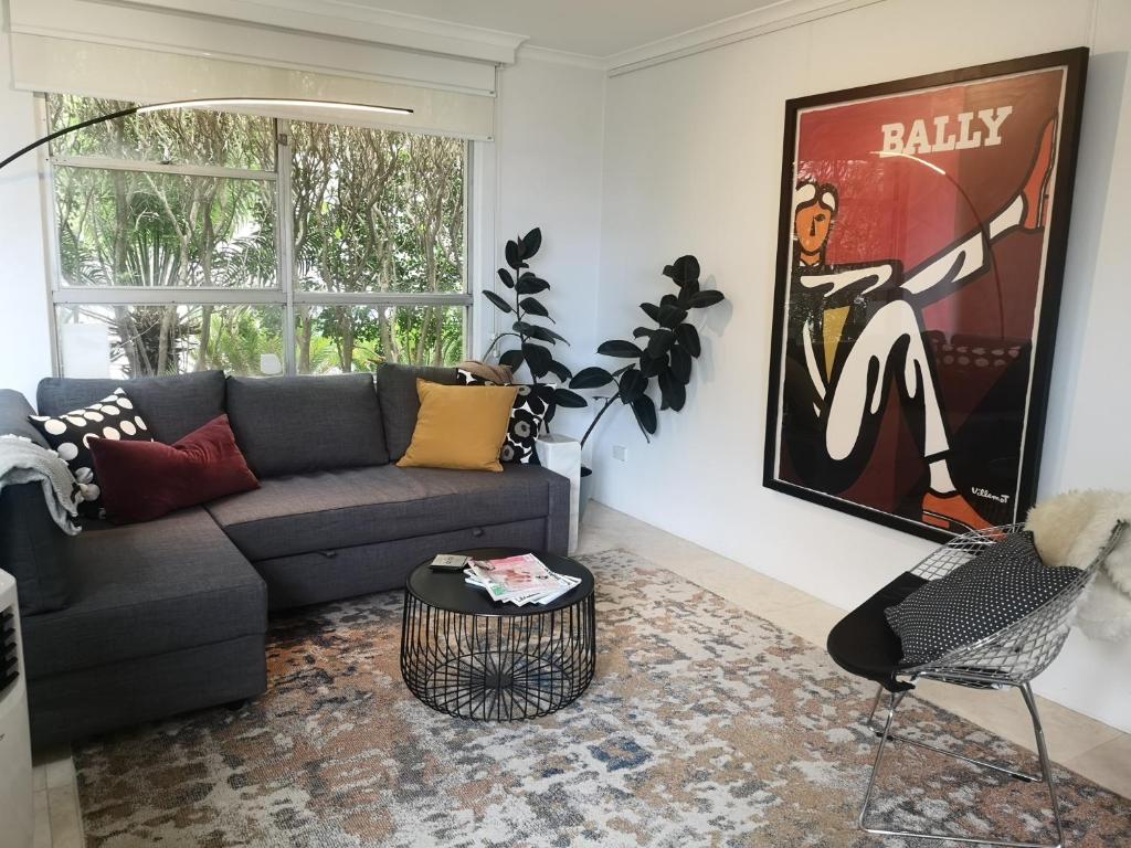a living room with a couch and a table at Harbourside7 - modern 1br unit with fab views in Sydney