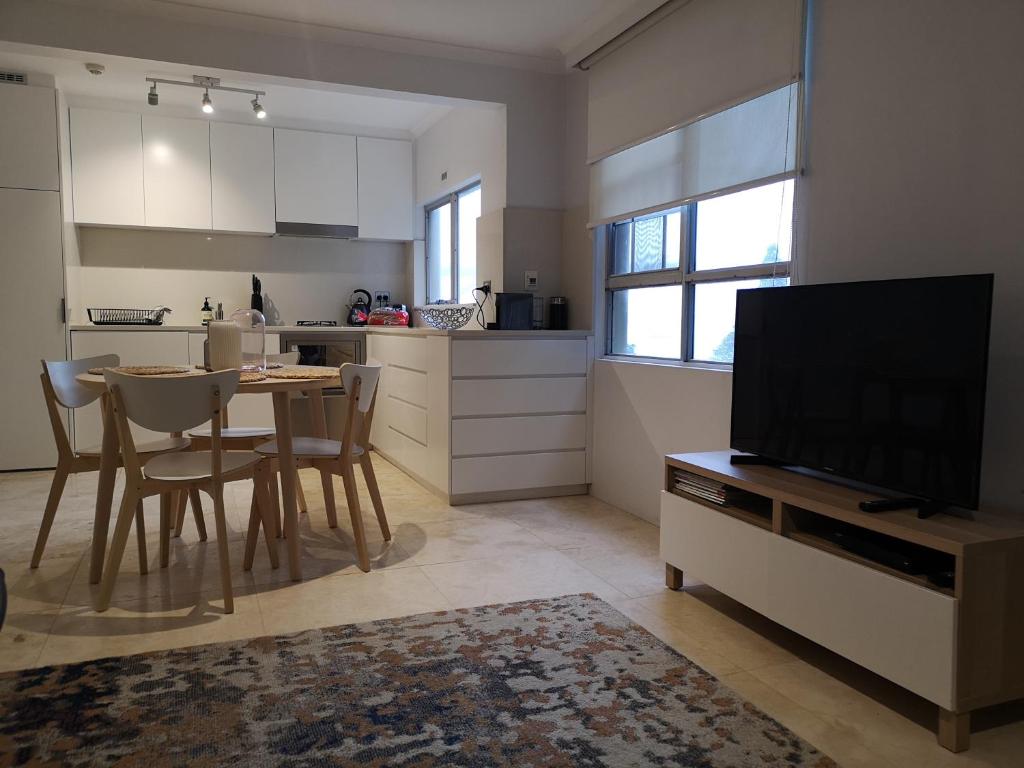 a kitchen with a table and a television in a room at Harbourside7 - modern 1br unit with fab views in Sydney