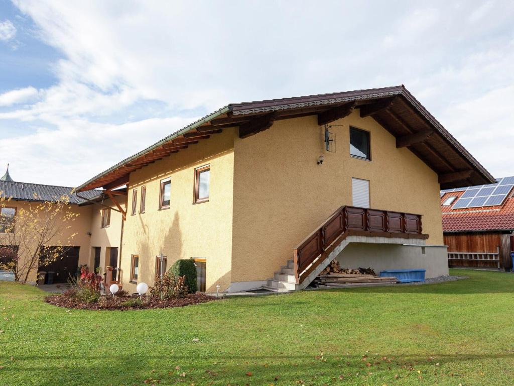 a large house with a grass yard in front of it at Cozy Apartment in Ruhmannsfelden with Swimming pool in Achslach