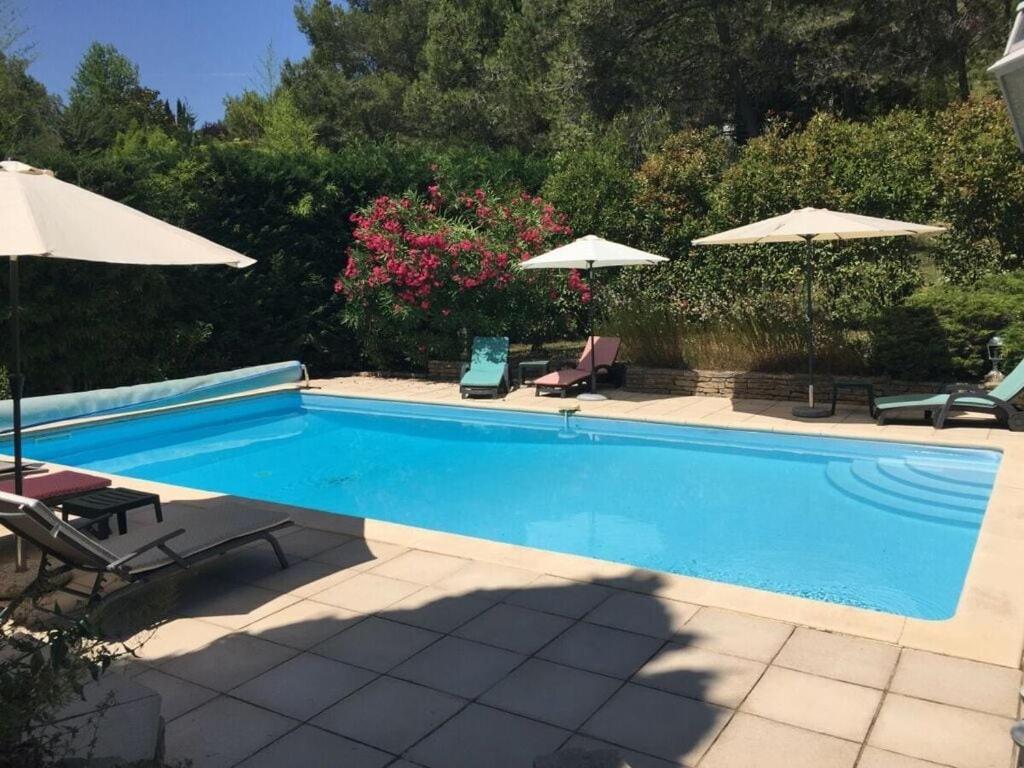 a swimming pool with two chairs and umbrellas at Charming apartment in Oberrieden in Oberrieden
