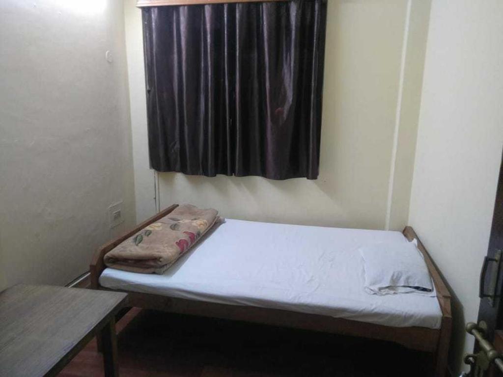 a small bed in a room with a window at Hotel J P Lodge Kalimpong in Kalimpong