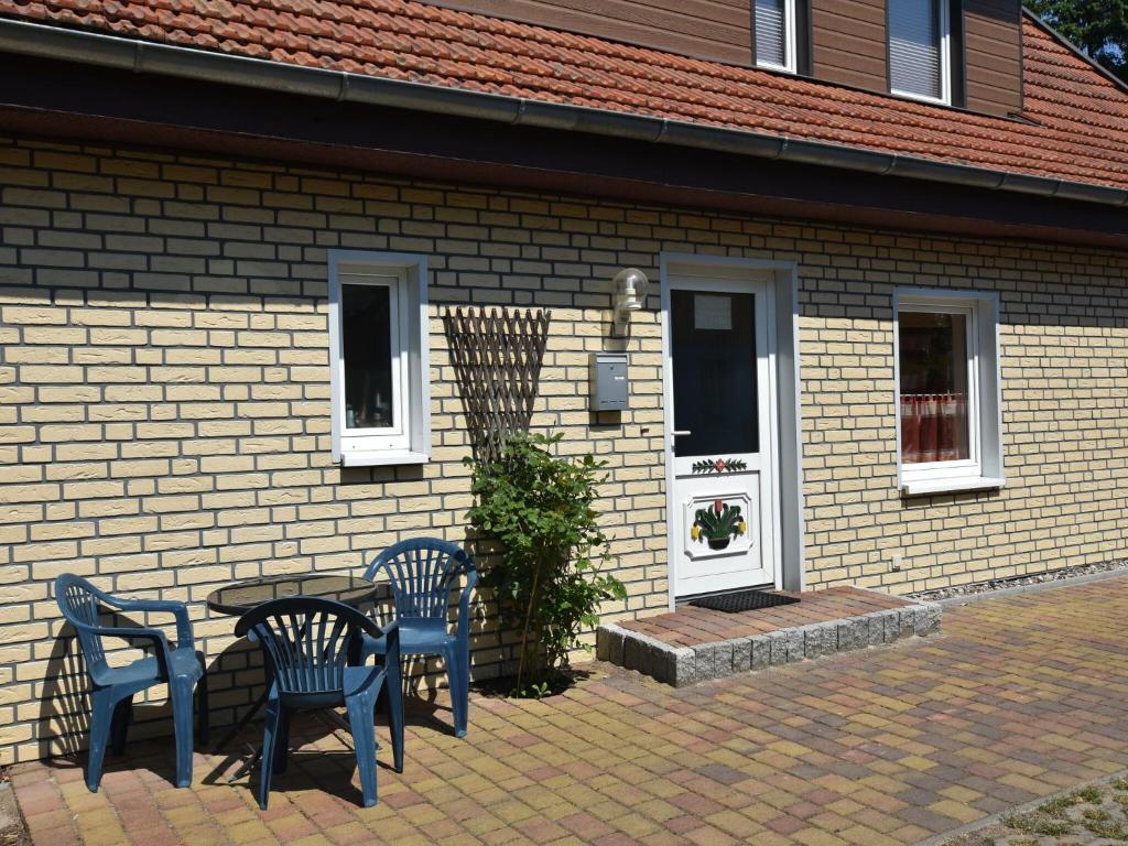 a table and chairs in front of a house at Spacious Apartment in Wieck auf dem DarB in Wieck