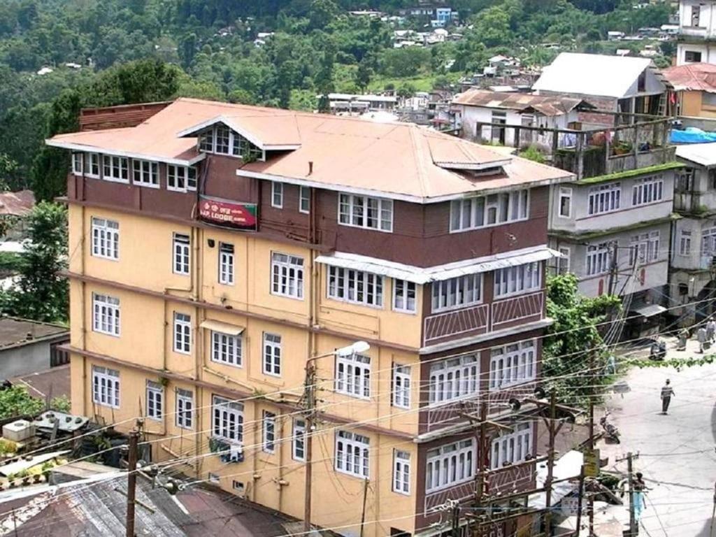 um grande edifício com janelas brancas numa cidade em Hotel J P Lodge Kalimpong em Kalimpong