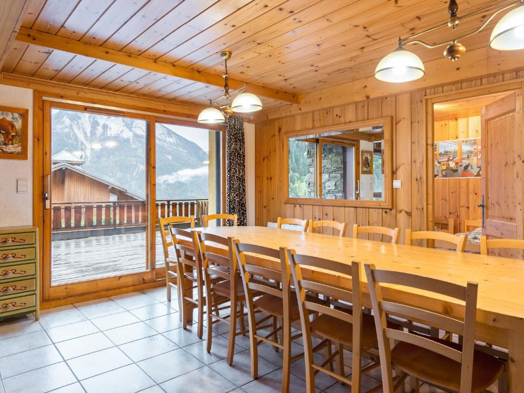 a dining room with a large wooden table and chairs at Spacious holiday home near center of Champagny in Le Villard