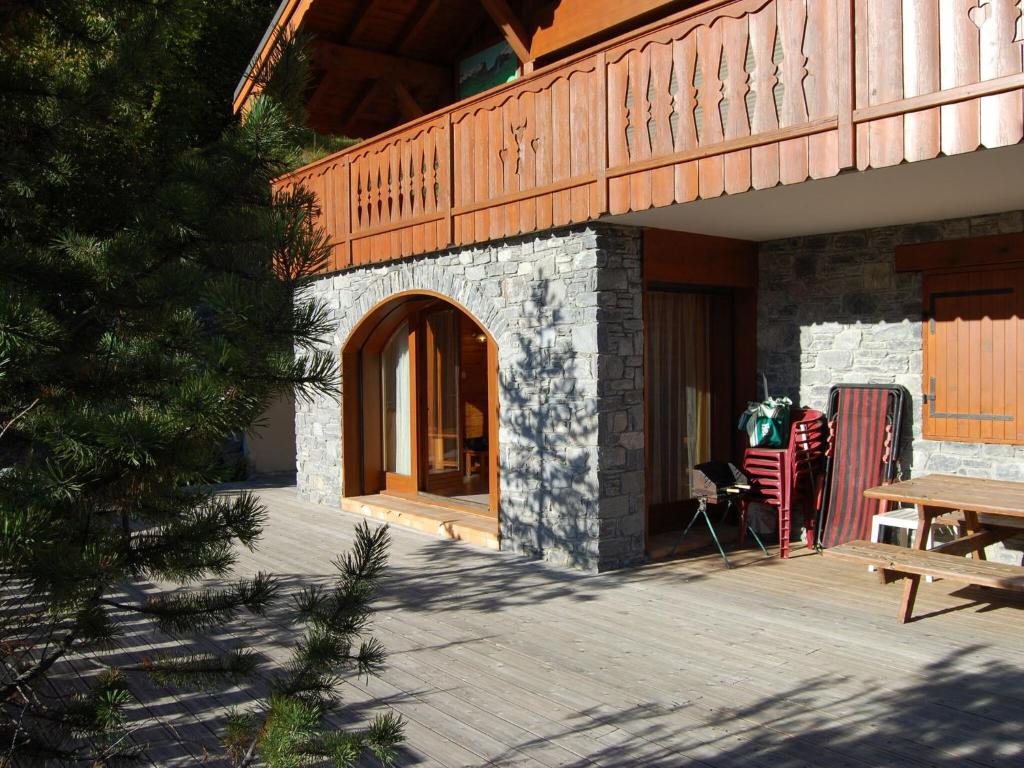 a patio with a wooden door and a wooden table at Spacious holiday home near center of Champagny in Le Villard