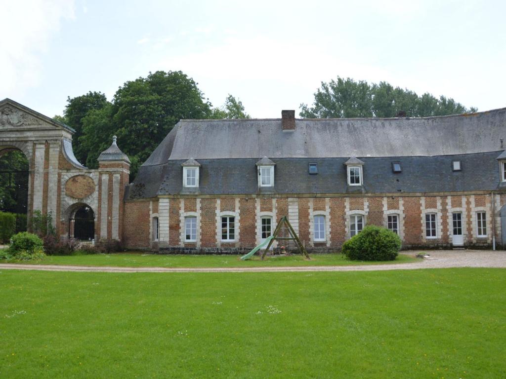 a large brick building with a gambrel roof at Holiday home in a historic building near Montreuil in Gouy-Saint-André