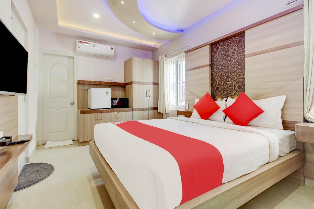 ein Schlafzimmer mit einem großen Bett mit roten Kissen in der Unterkunft OYO OYO Emara Boutique Hotel Nearby Koramangala Forum Mall in Bangalore