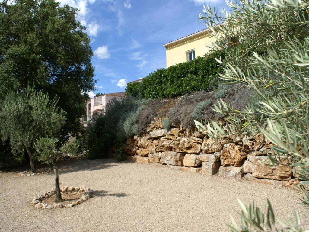 a stone wall with a small tree in a garden at Beautiful Villa in Vidauban with seasonal Pool in Vidauban